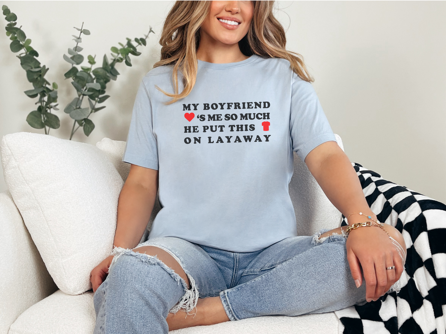 a woman sitting on a couch wearing a t - shirt that says, my boyfriend