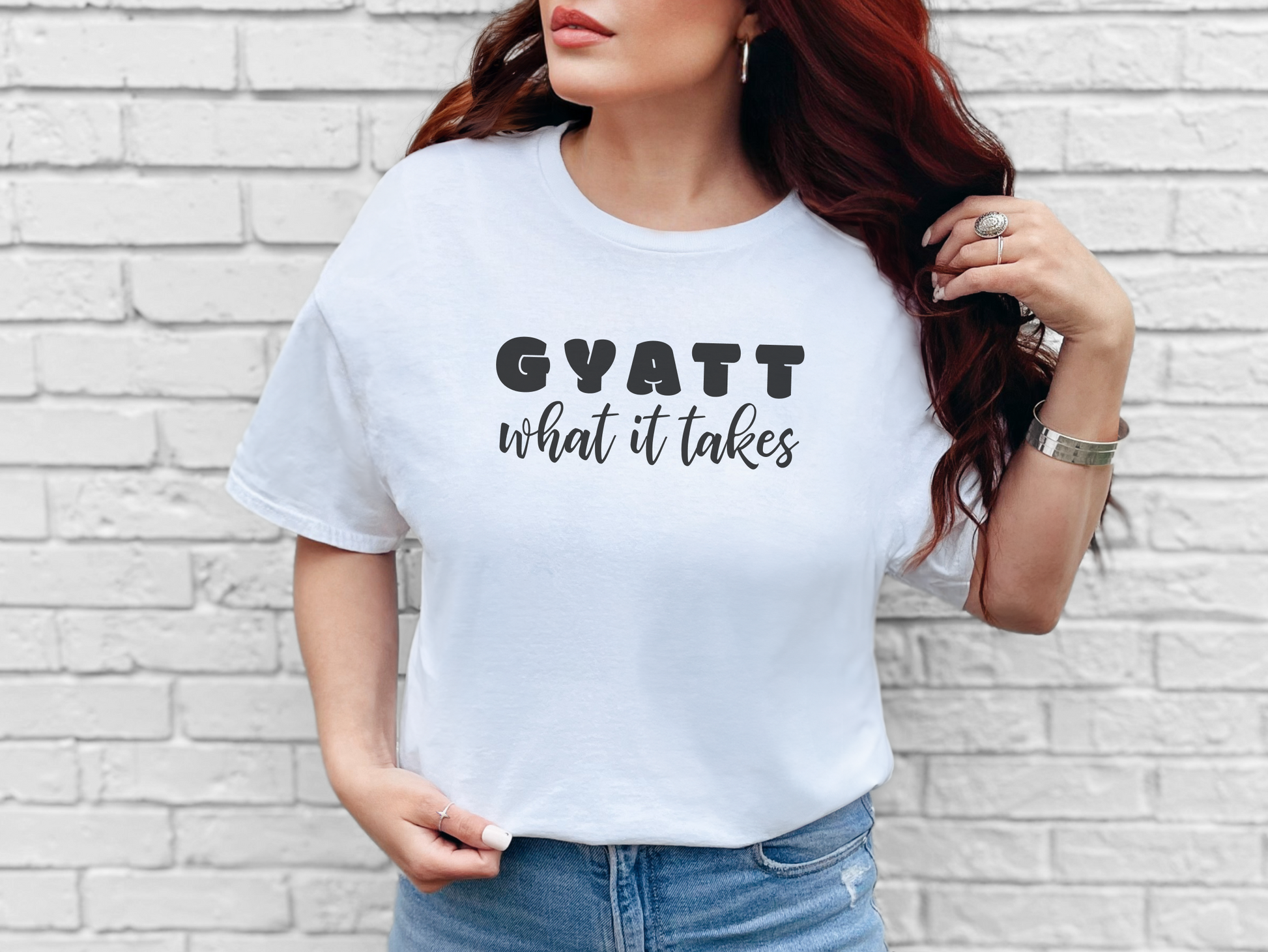 a woman wearing a white shirt that says gyatt what it takes