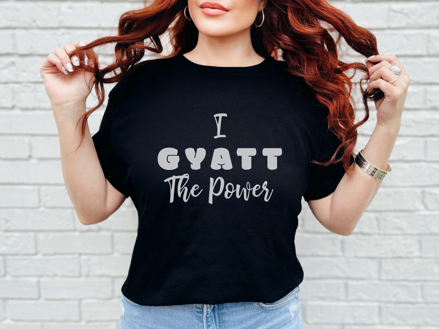 a woman wearing a black shirt that says i gyatt the power