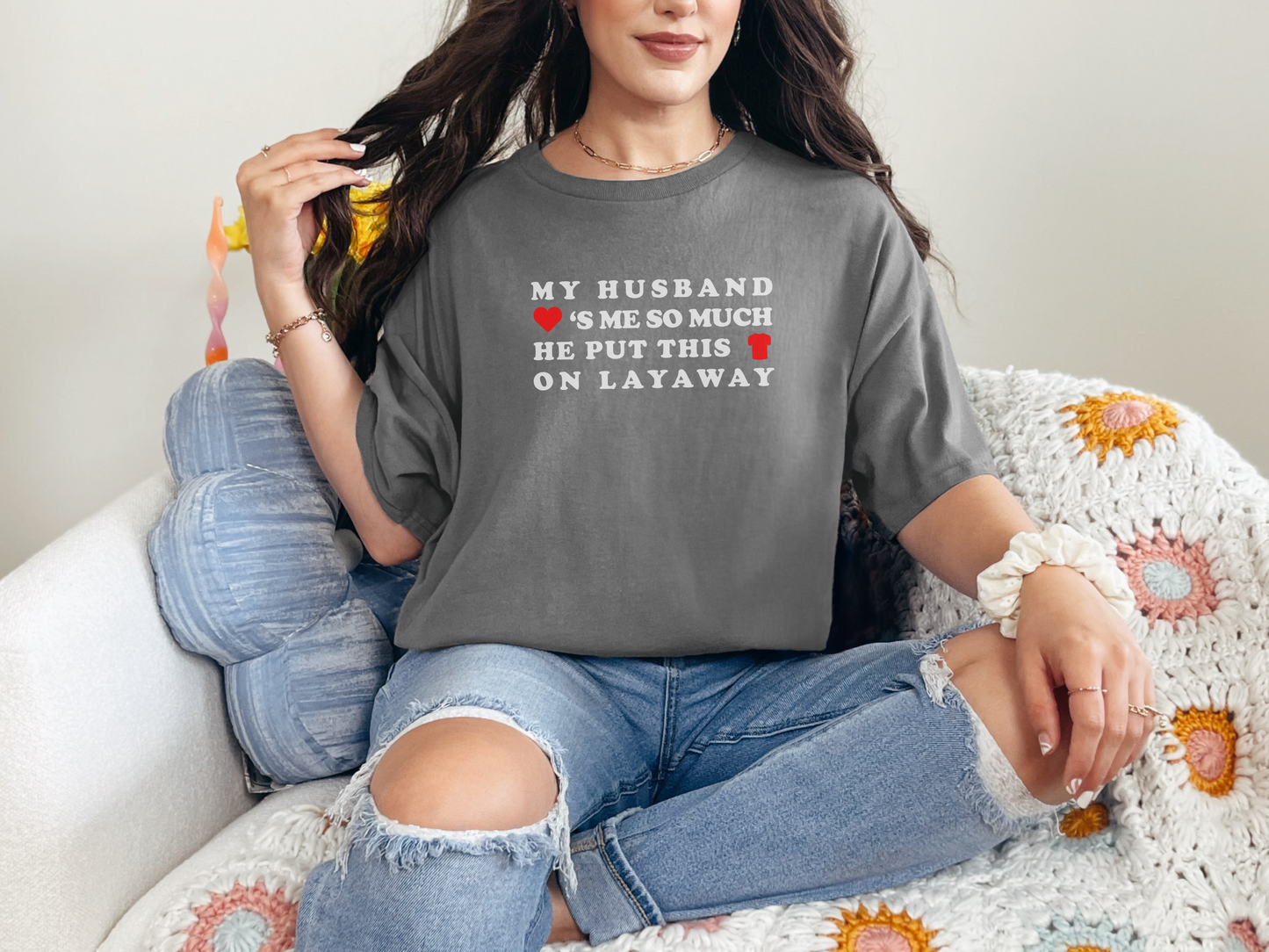 a woman sitting on a couch wearing a t - shirt that says, my husband