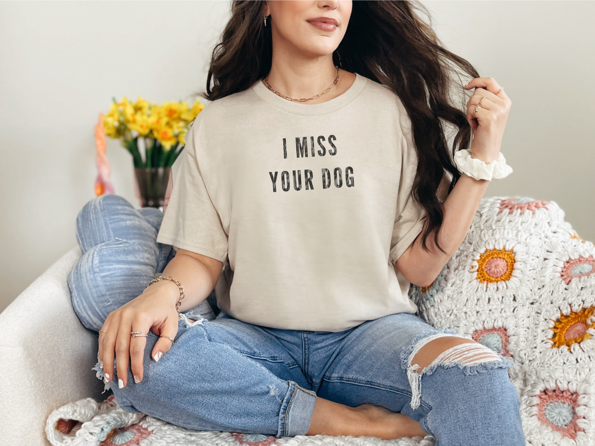 a woman sitting on a couch wearing a t - shirt that says i miss your