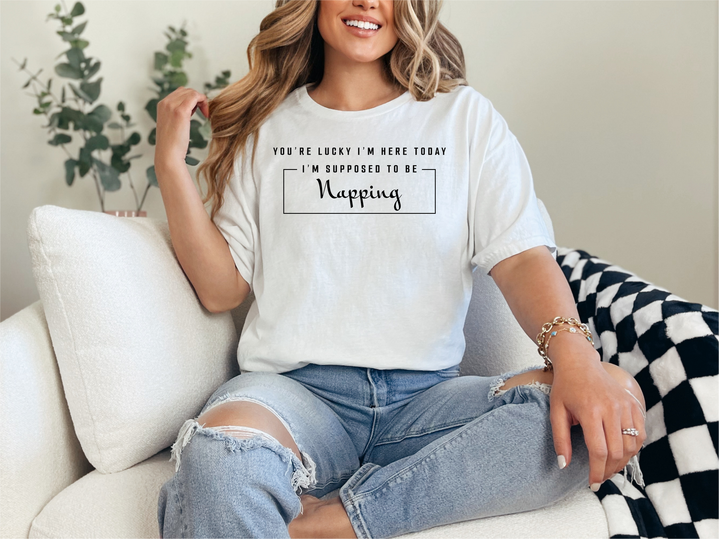 a woman sitting on a couch wearing a t - shirt that says, you '