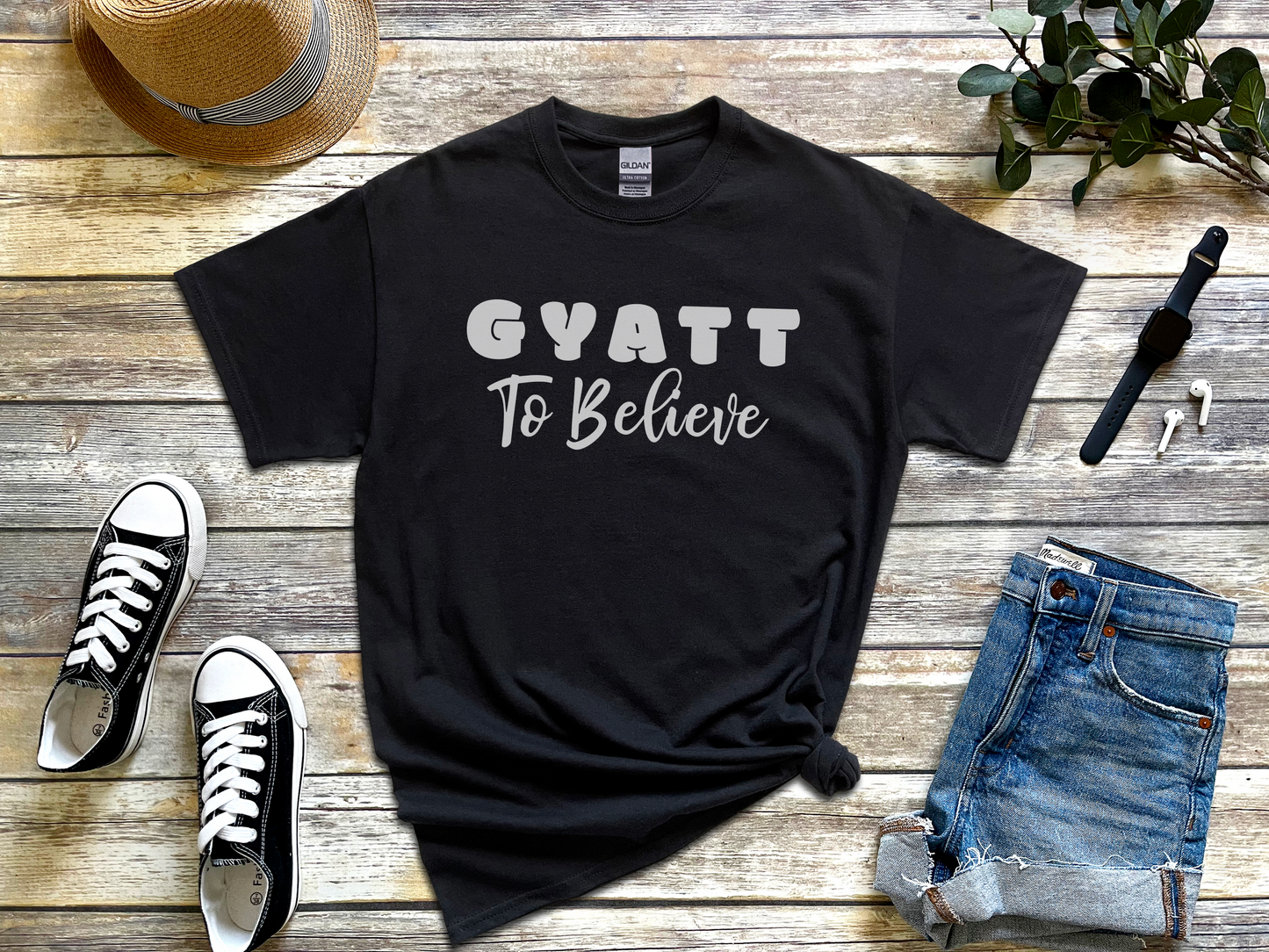 a t - shirt that says gyatt to believe next to a pair of