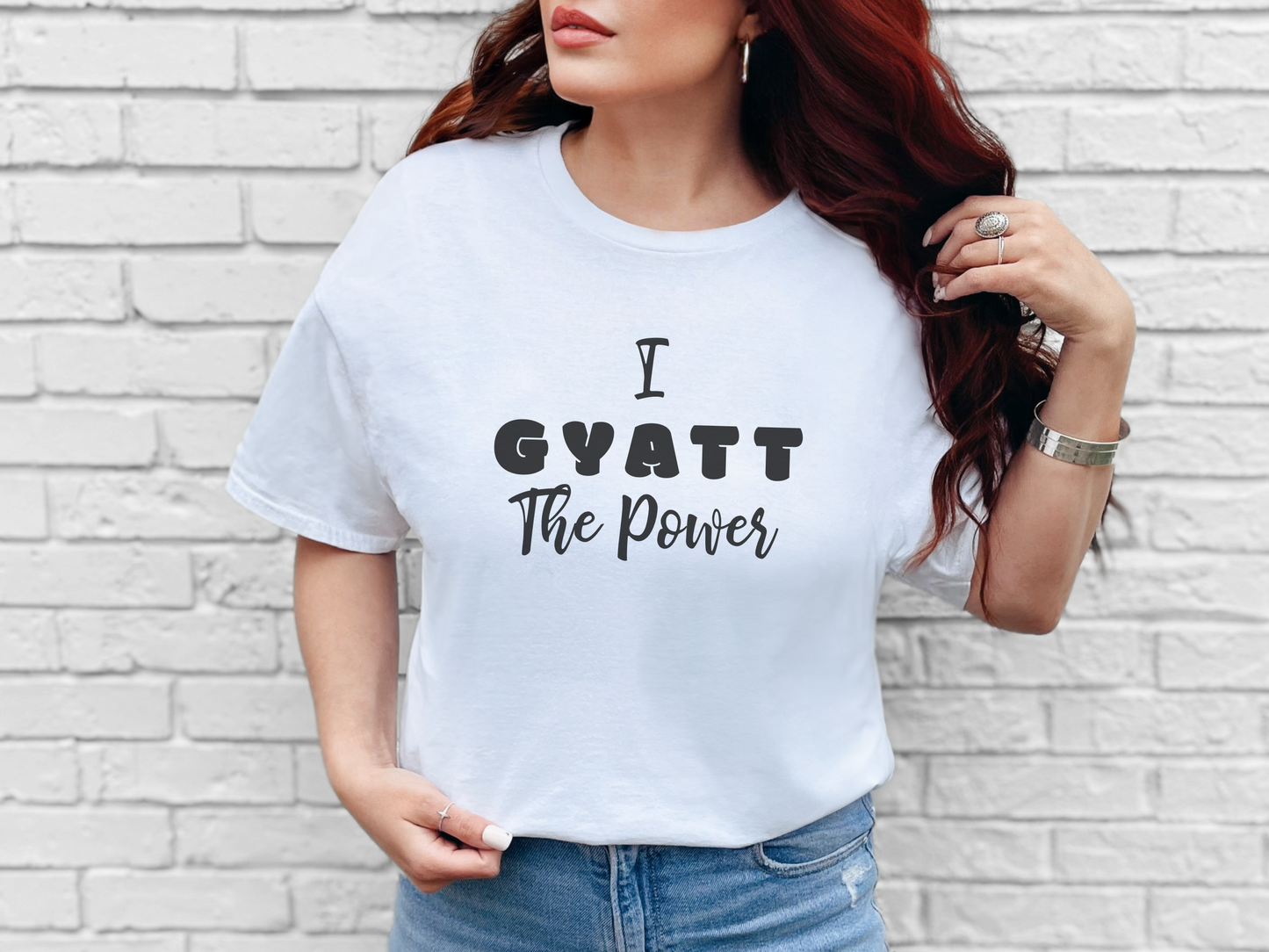 a woman wearing a white t - shirt that says i gyatt the power