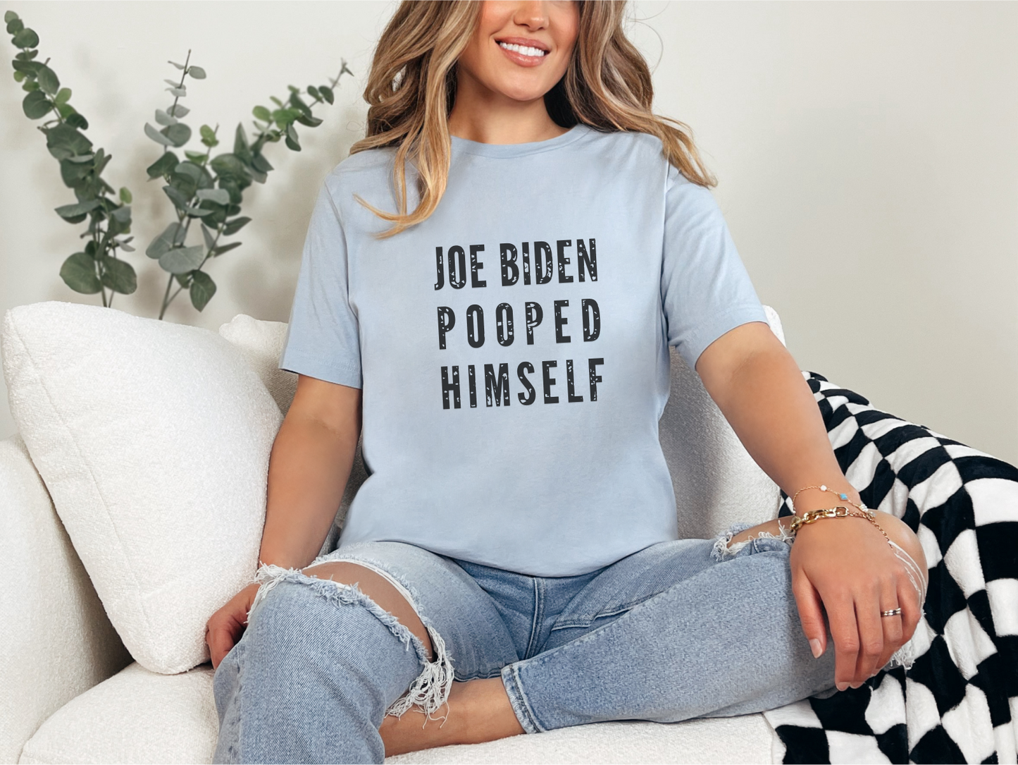 a woman sitting on a couch wearing a t - shirt that says joe eden po