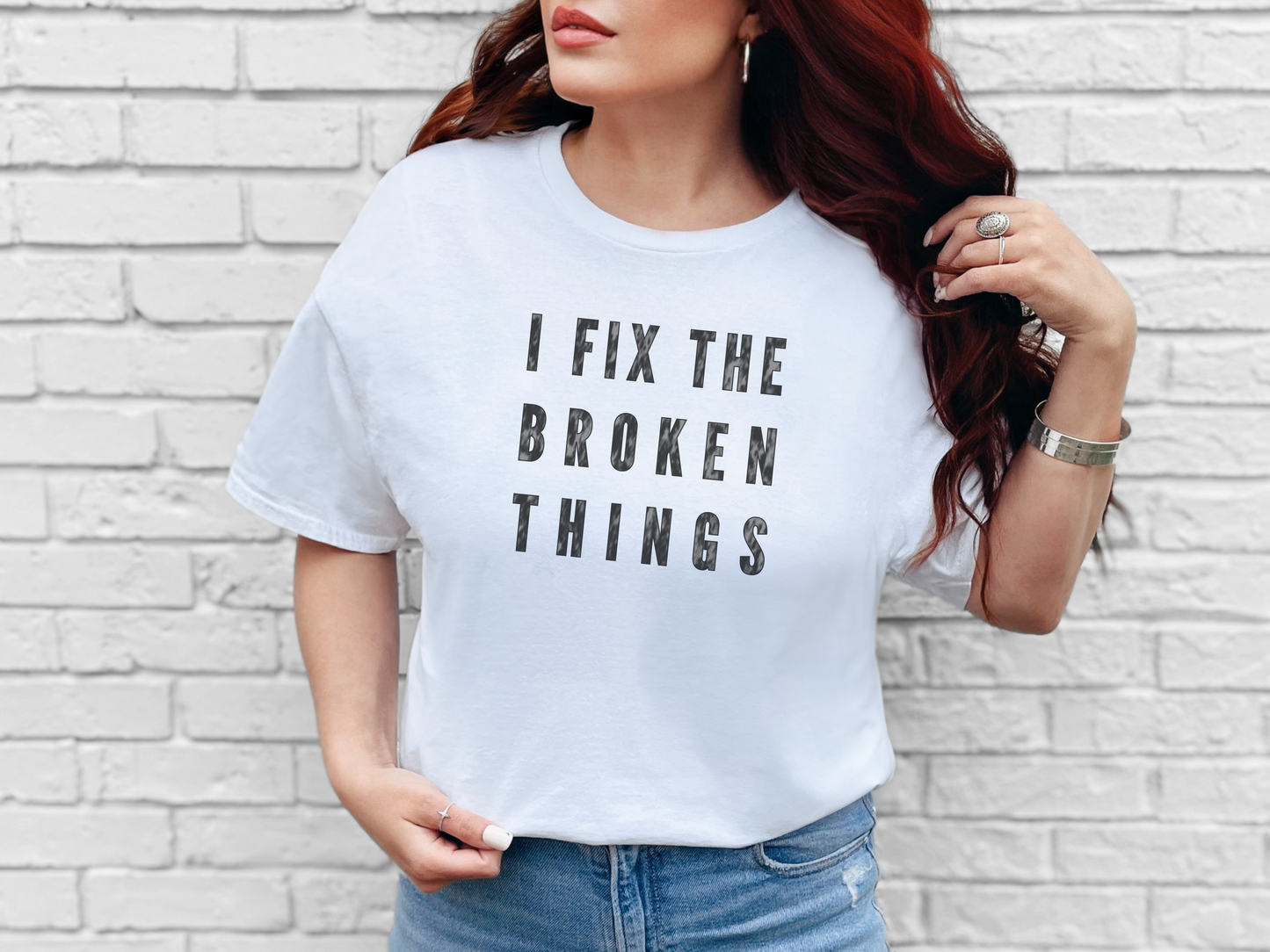 a woman wearing a white t - shirt that says i fix the broken things