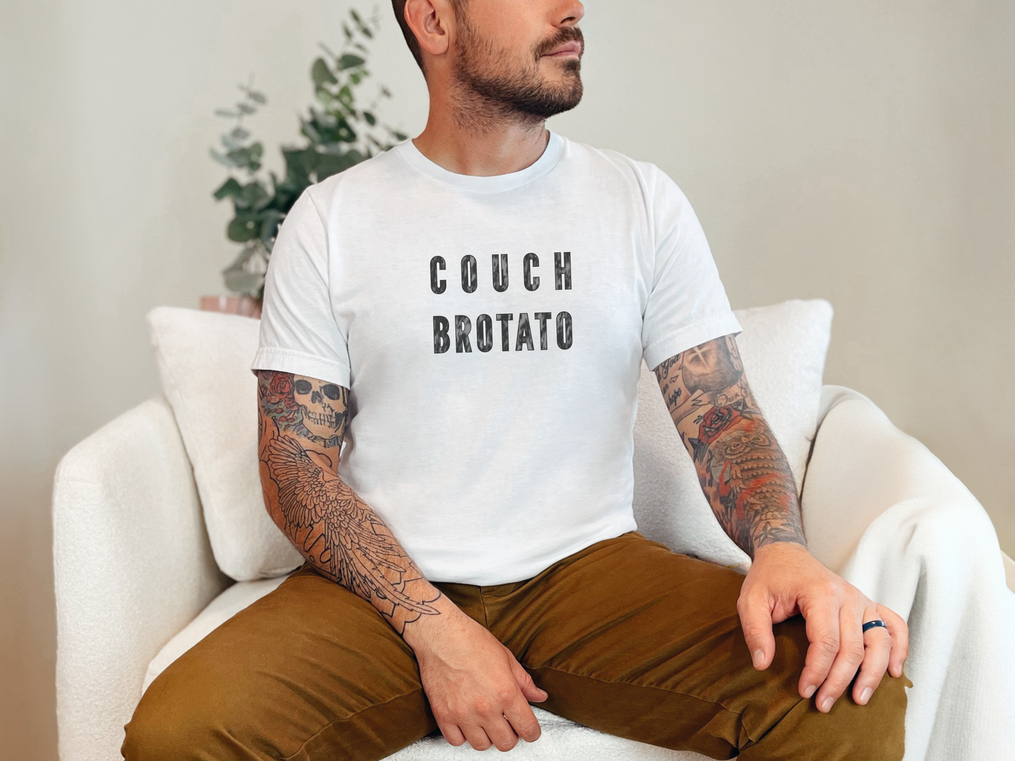 a man with tattoos sitting on a white chair