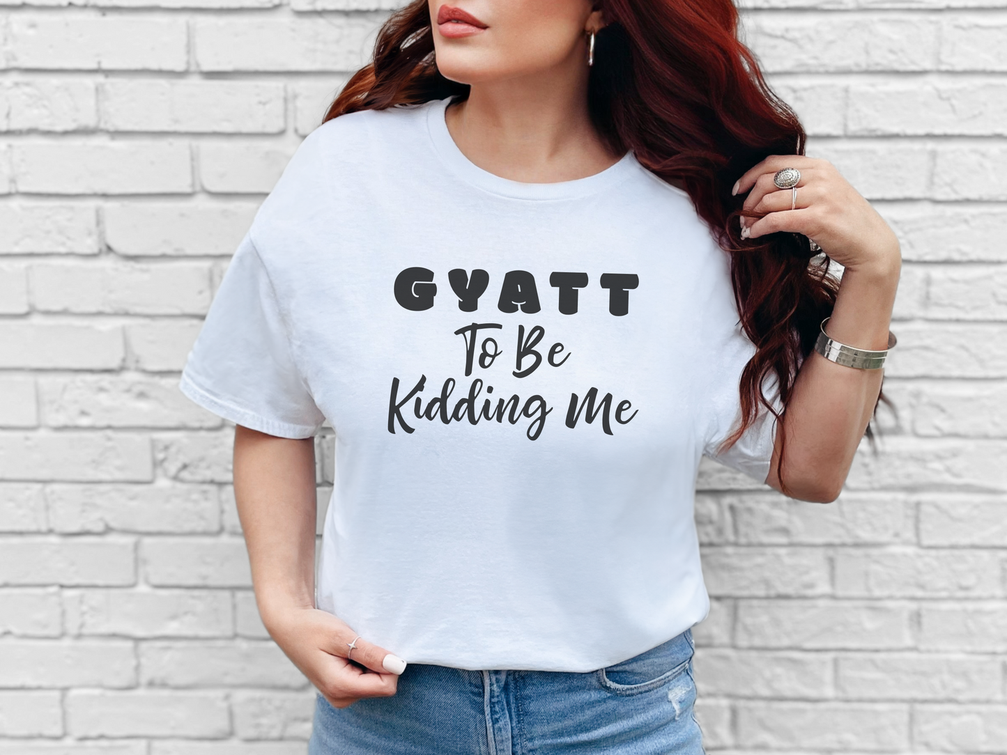 a woman wearing a white shirt that says gyatt to be riding me