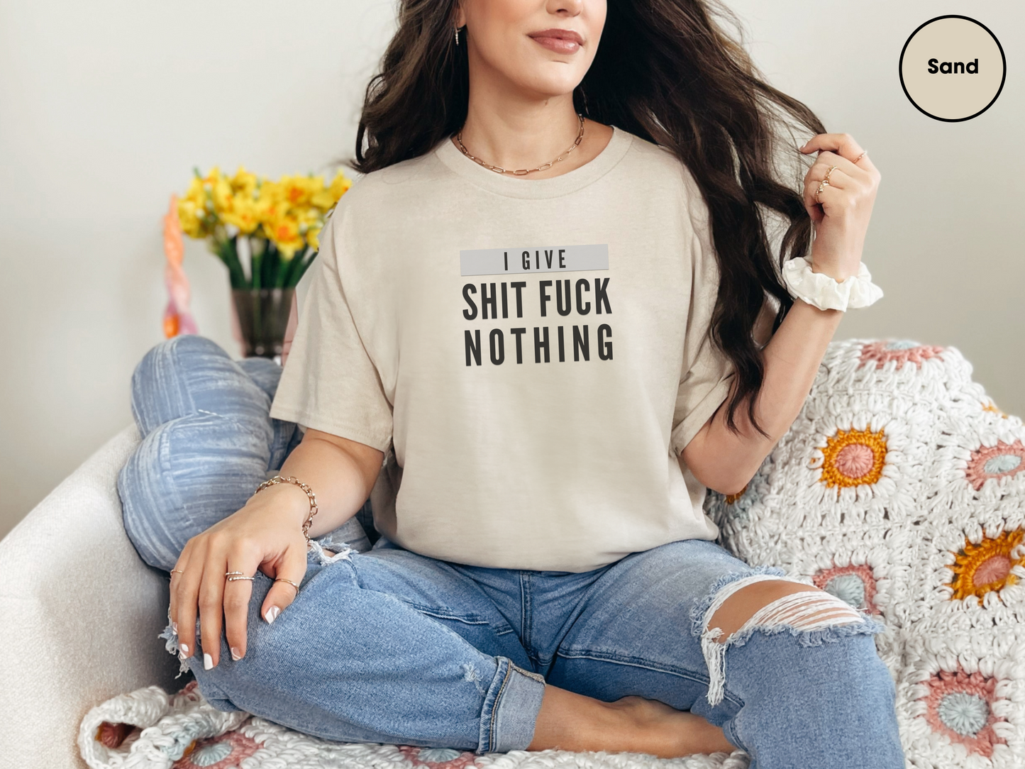 a woman sitting on a couch wearing a t - shirt that says i love shit