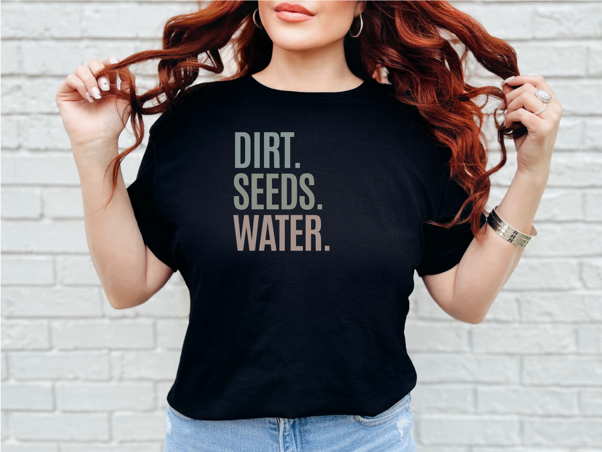 a woman wearing a black shirt that says dirt seeds water