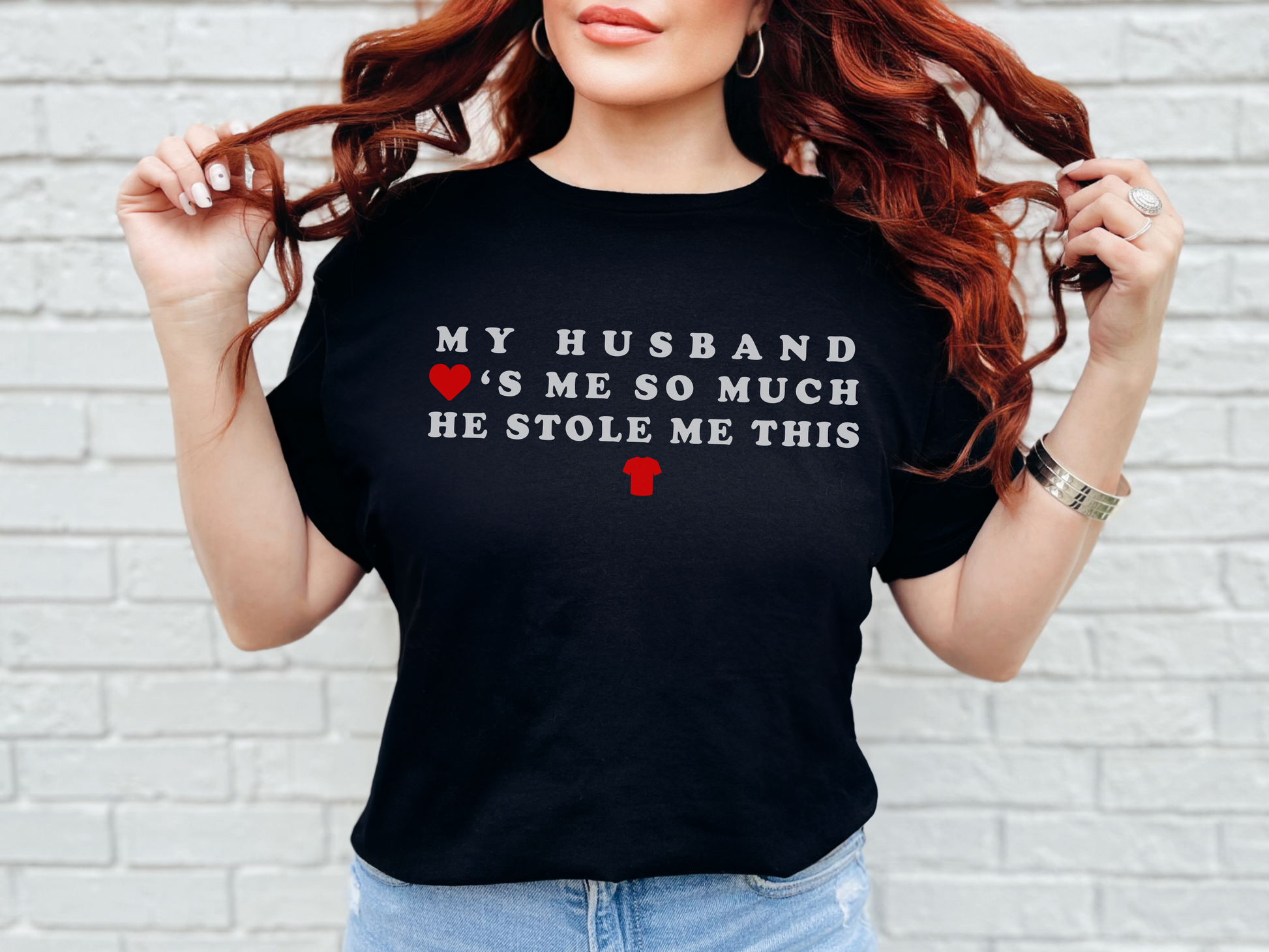 a woman with red hair wearing a black t - shirt that says my husband is