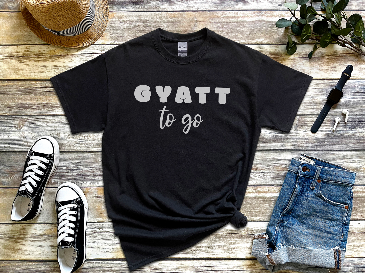 a black t - shirt that says gyatt to go next to a pair