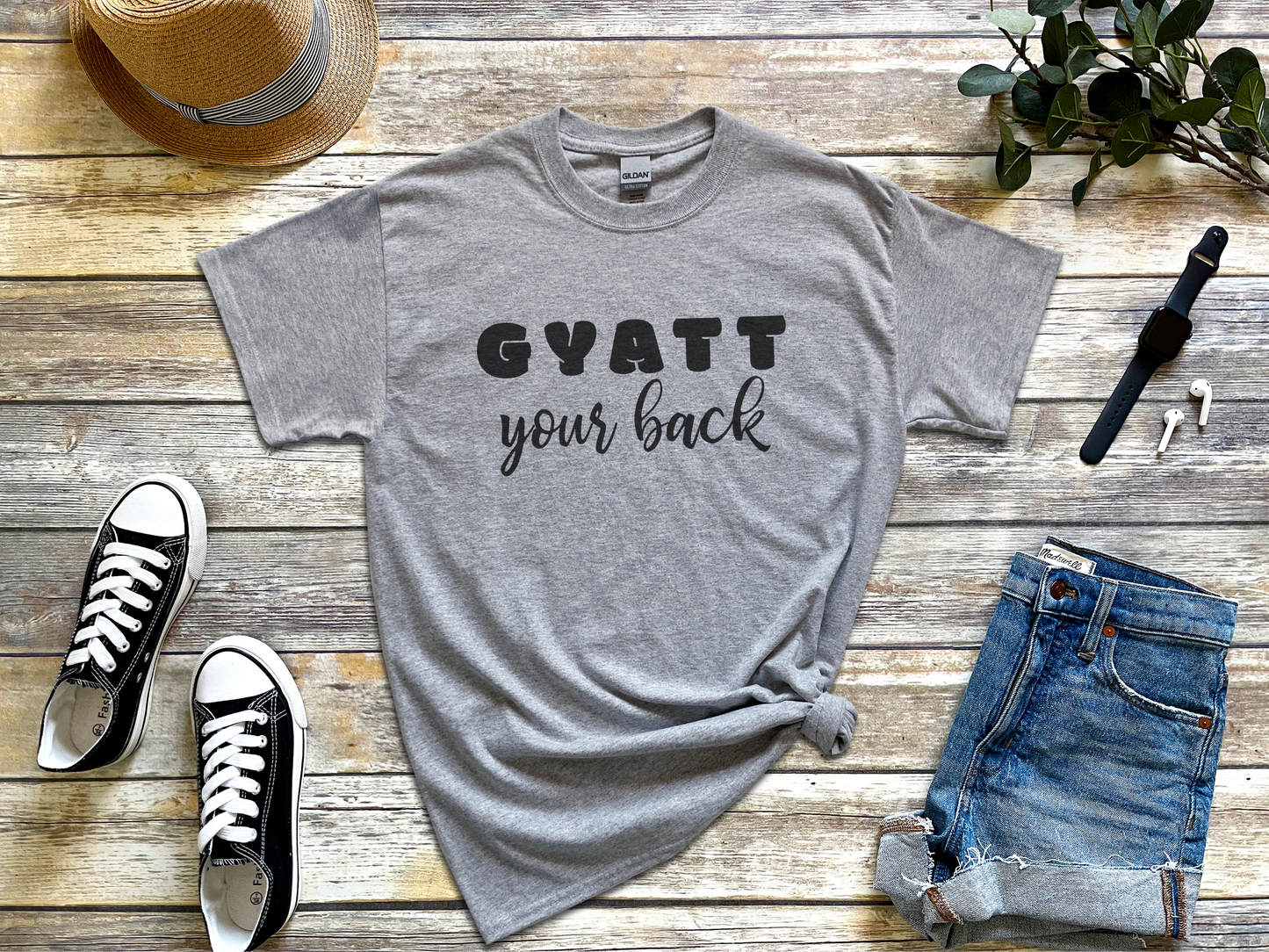 a t - shirt that says gyatt your back next to a pair of