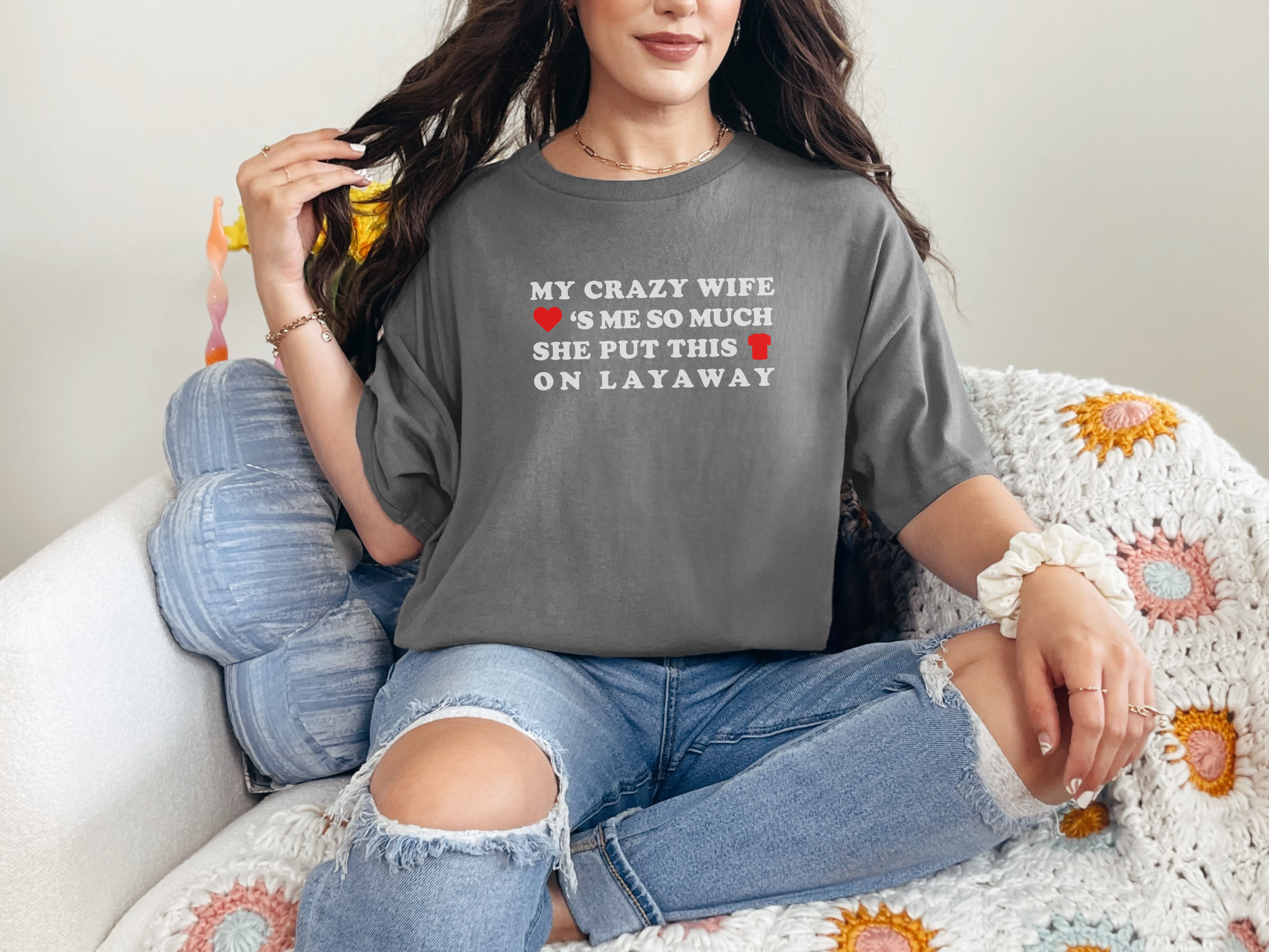 a woman sitting on a couch wearing a gray shirt