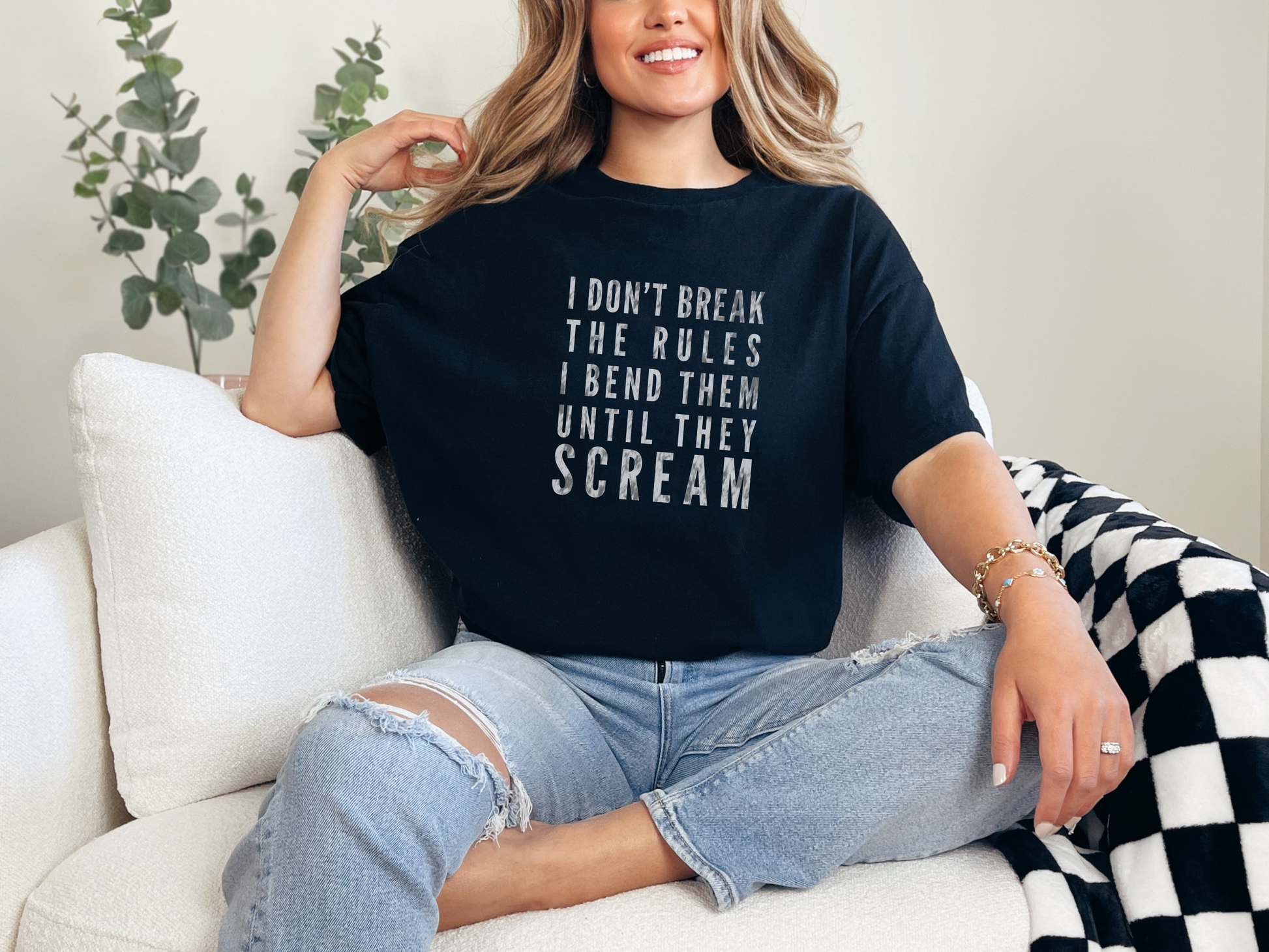 a woman sitting on a couch wearing a t - shirt that says i don '