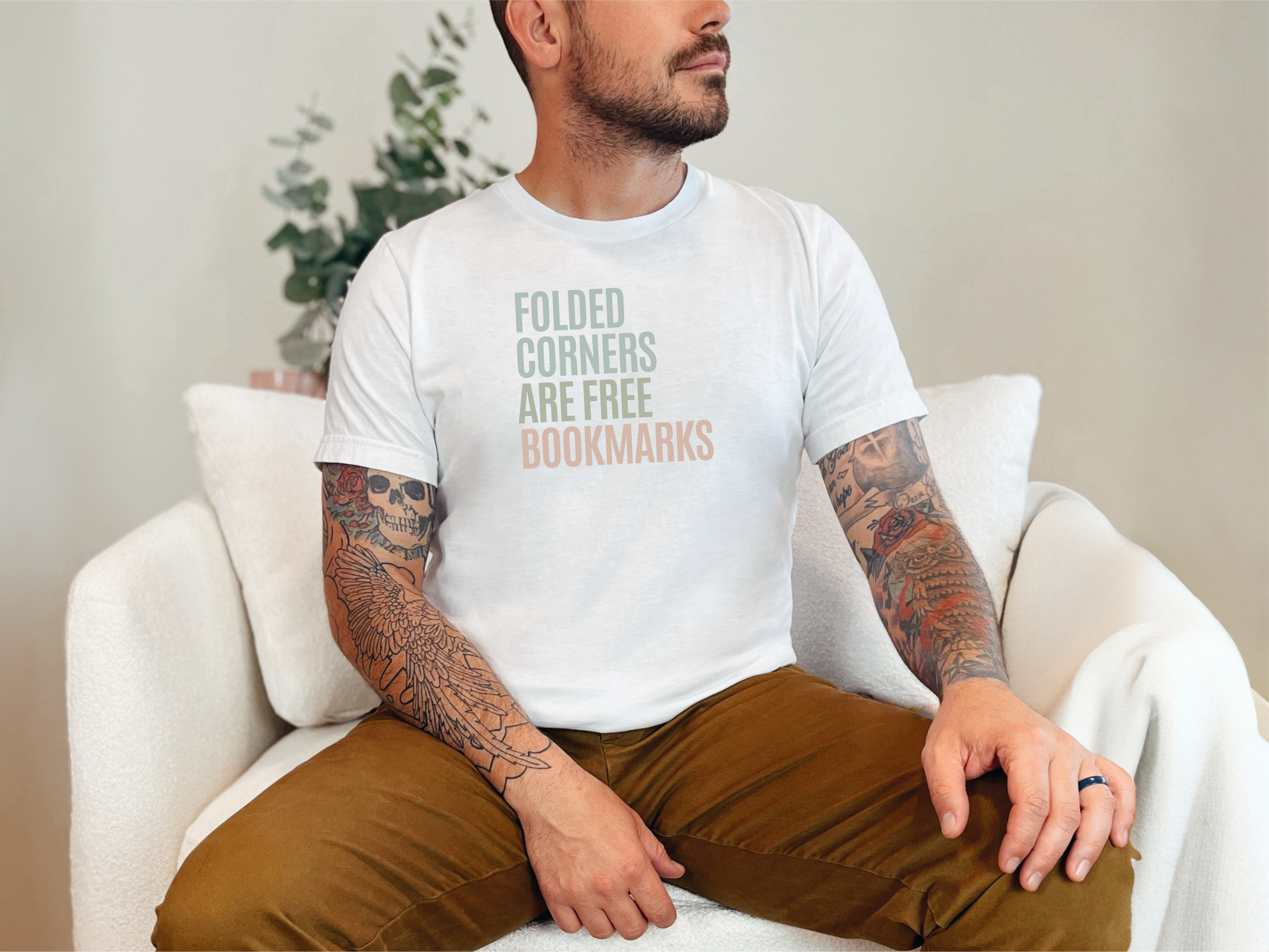 a man with a tattooed arm sitting on a white chair