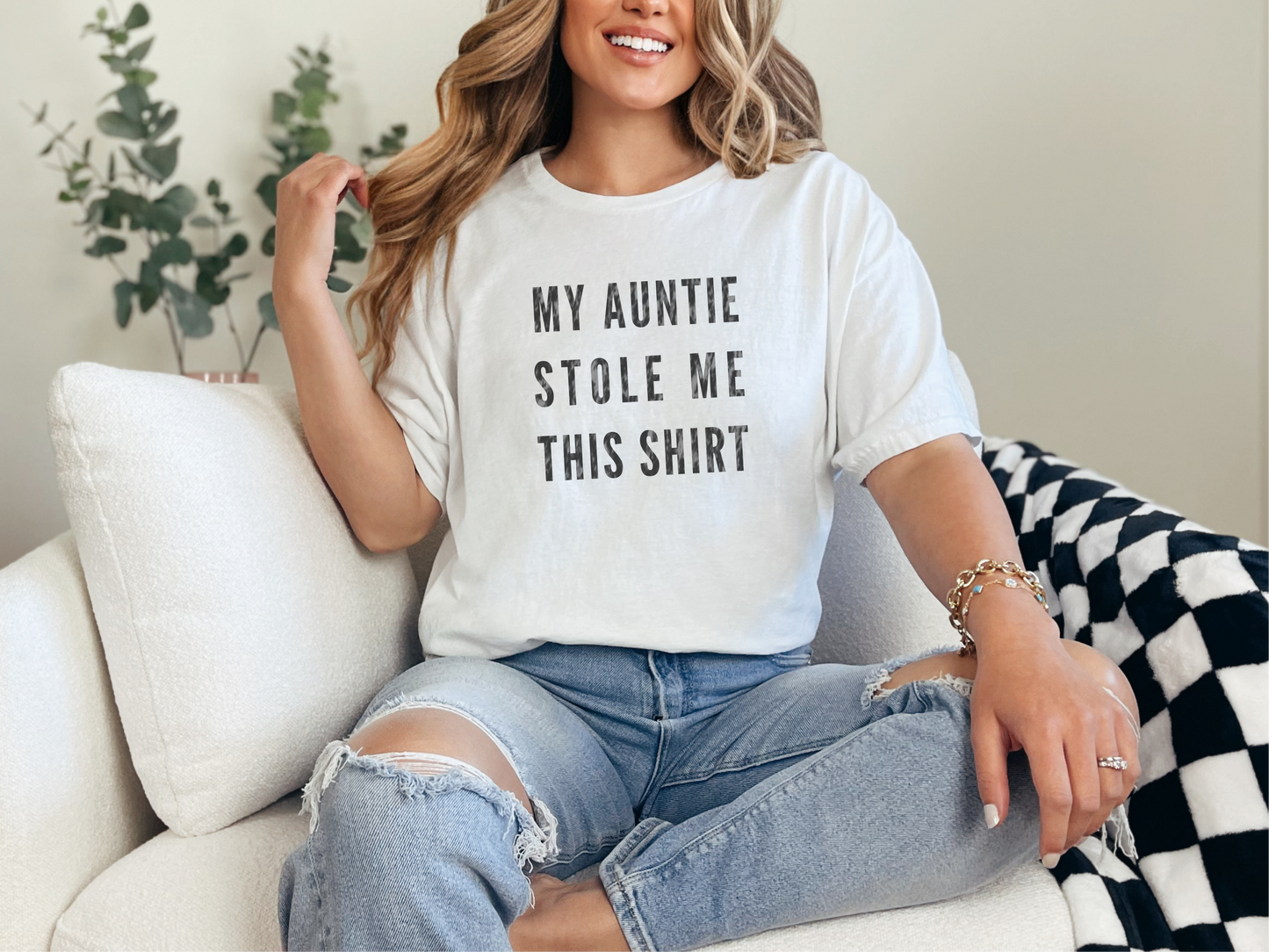 a woman sitting on a couch wearing a white tee shirt that says, my ann