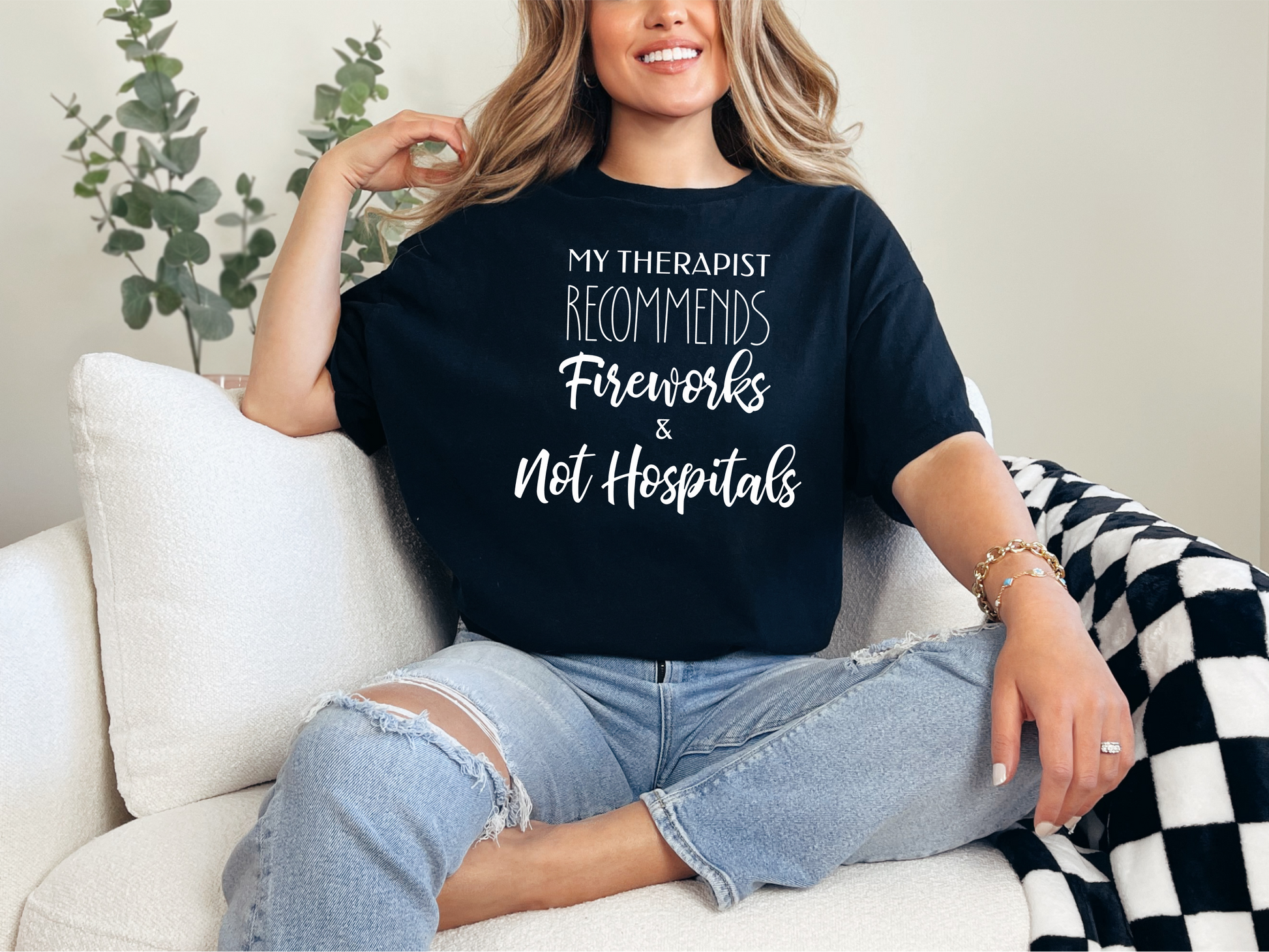 a woman sitting on a couch wearing a t - shirt that says my thera