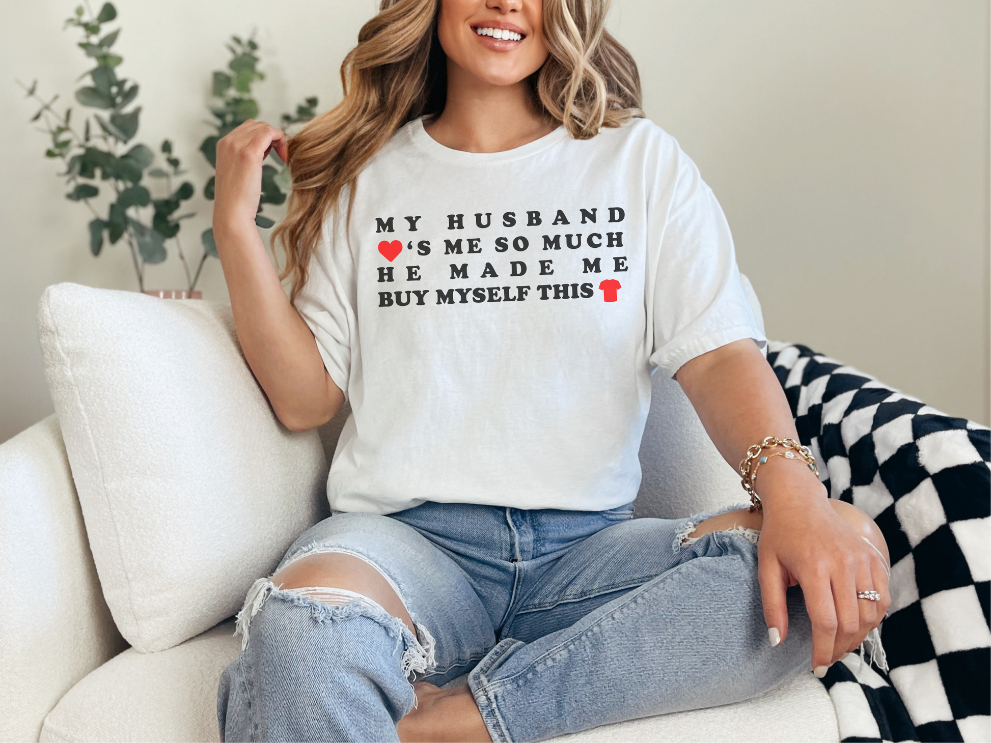 a woman sitting on a couch wearing a white t - shirt