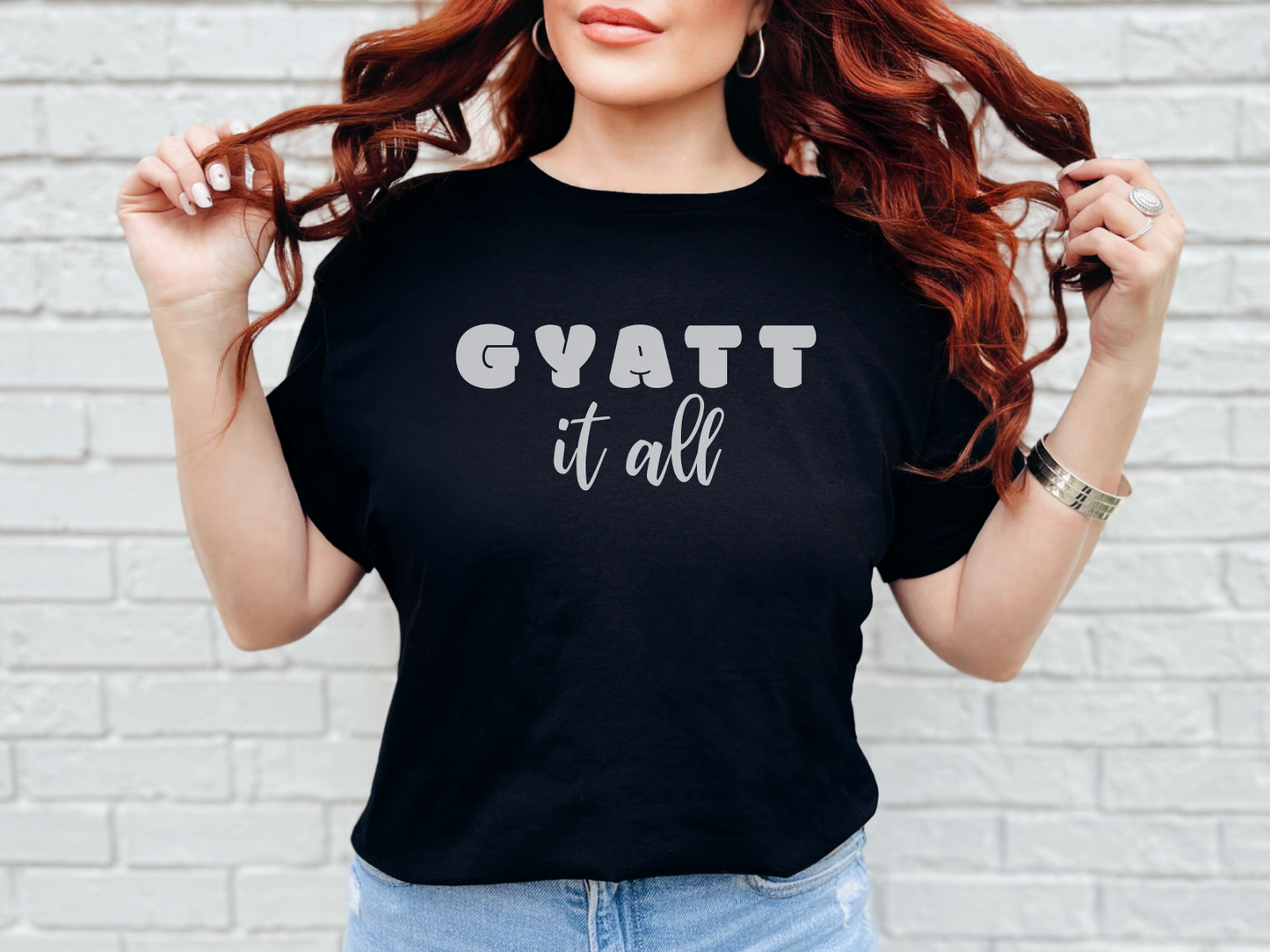 a woman wearing a black shirt that says gyatt it all