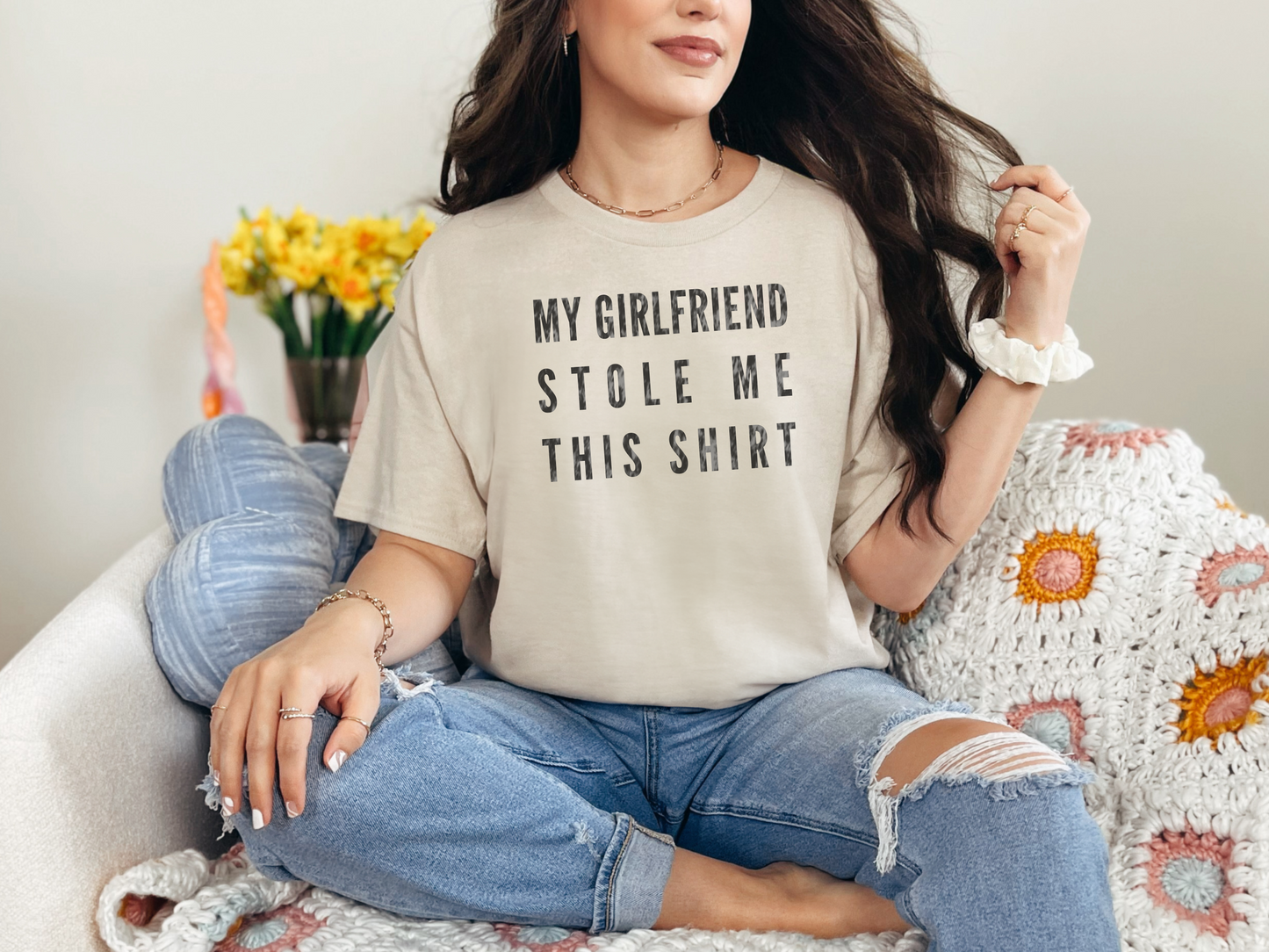 a woman sitting on a couch wearing a shirt that says my girlfriend stole me this