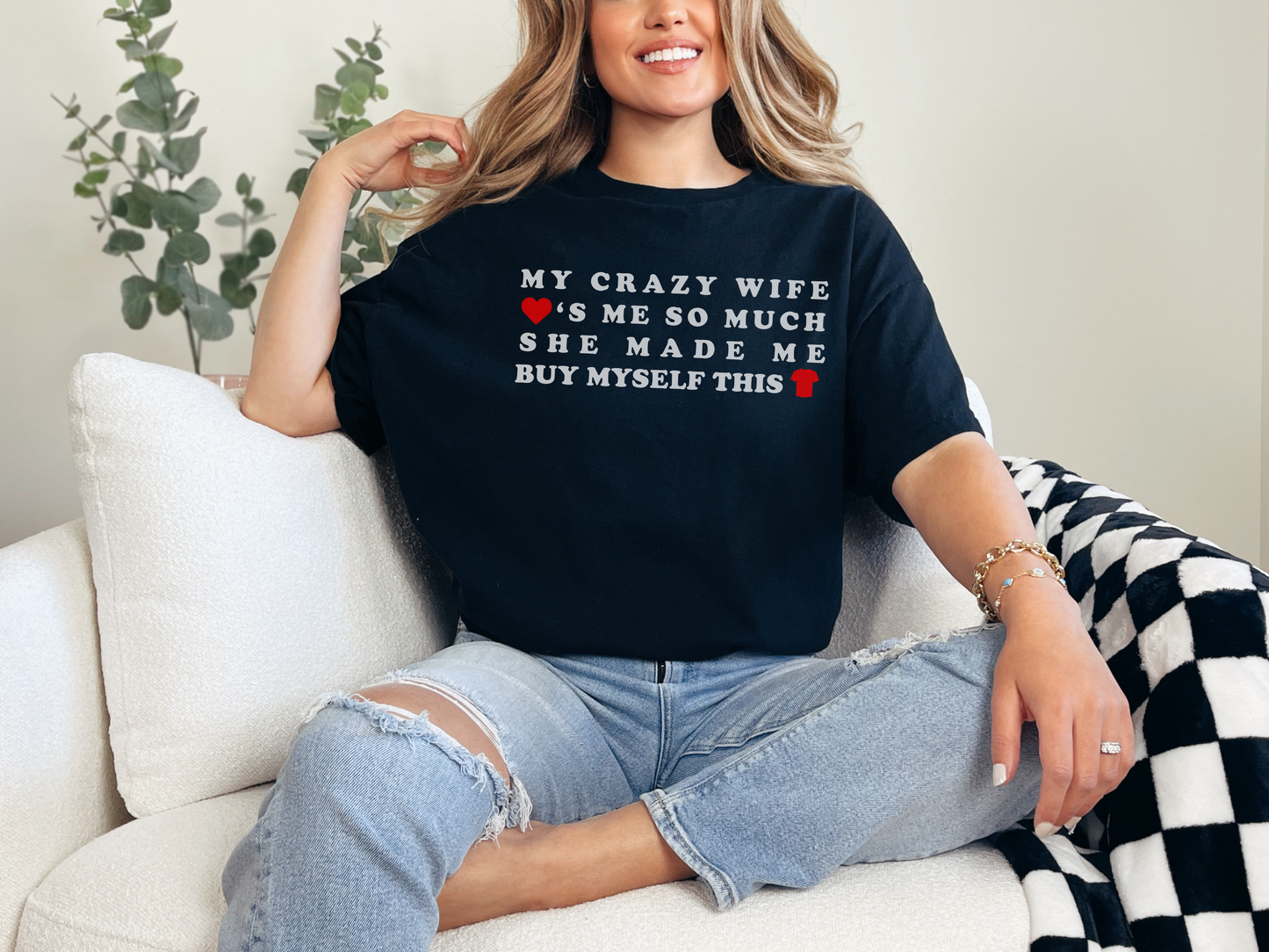 a woman sitting on a couch wearing a black shirt