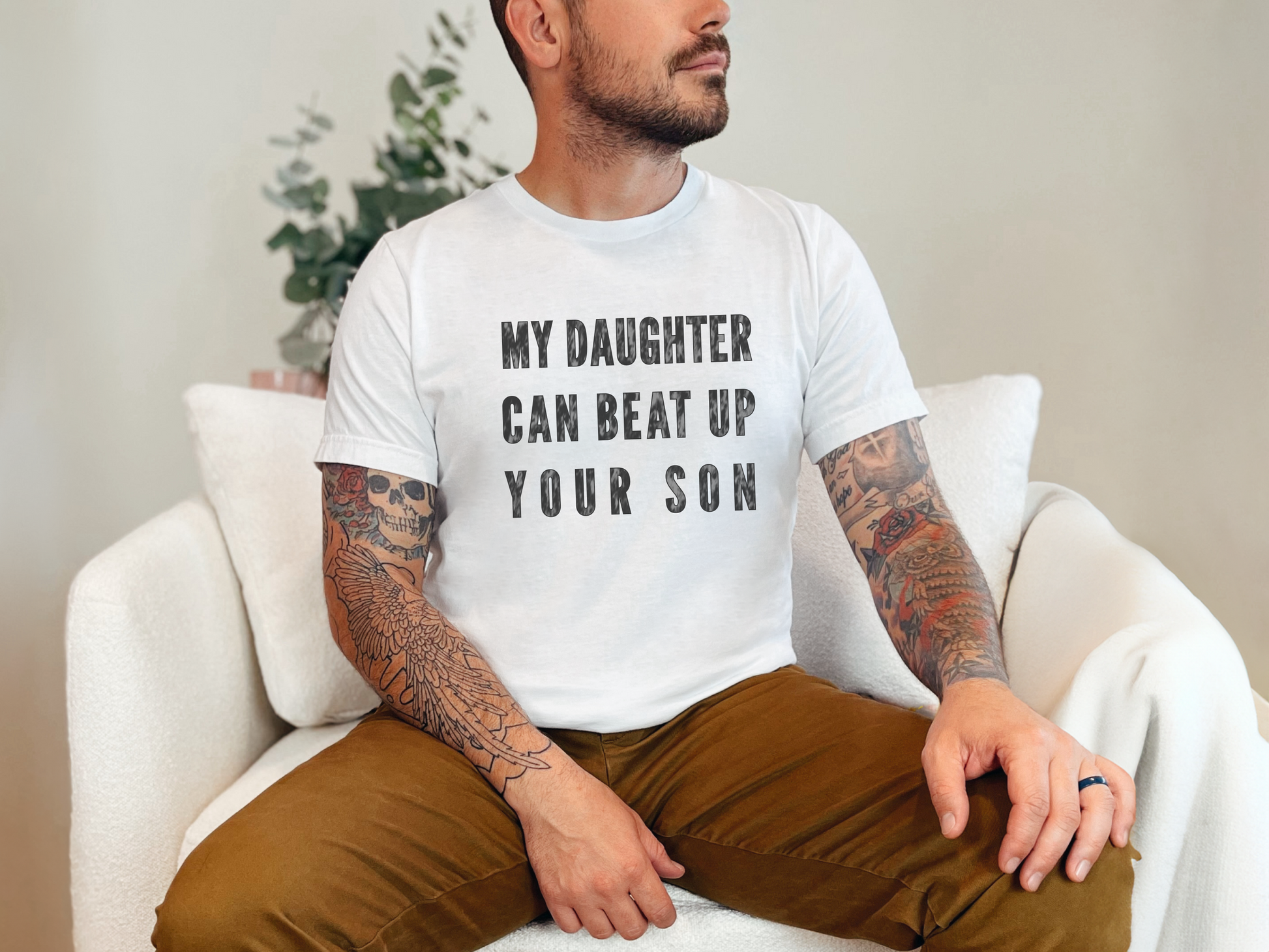 a man with a tattooed arm sitting on a white chair