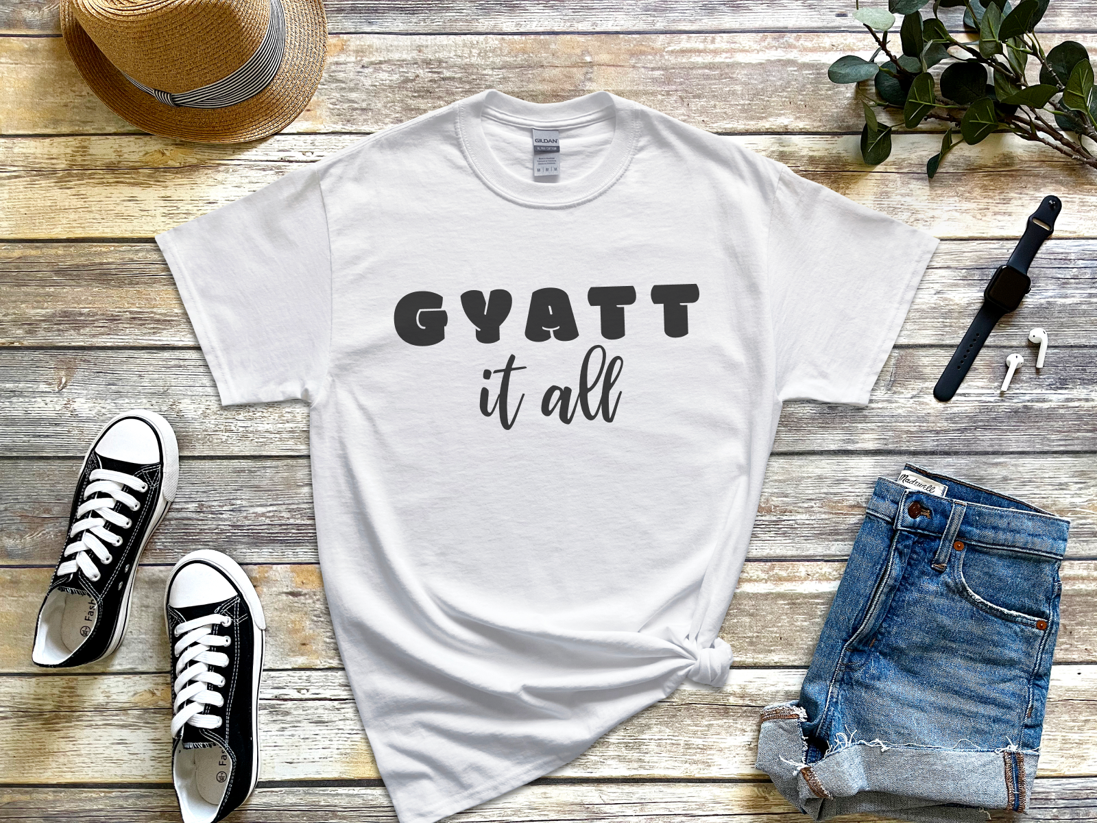 a t - shirt that says gyatt it all next to a pair of