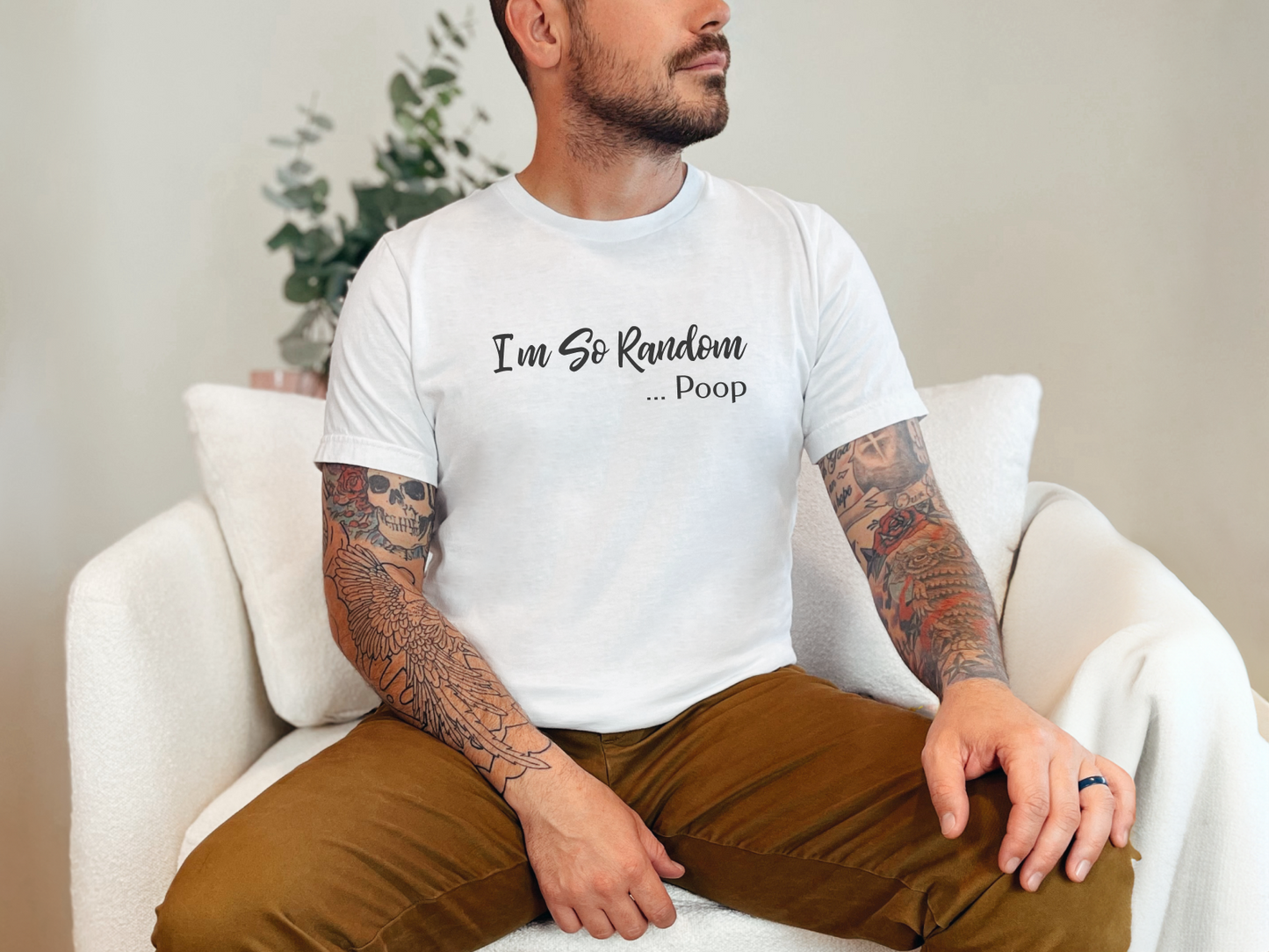 a man with tattoos sitting on a white chair