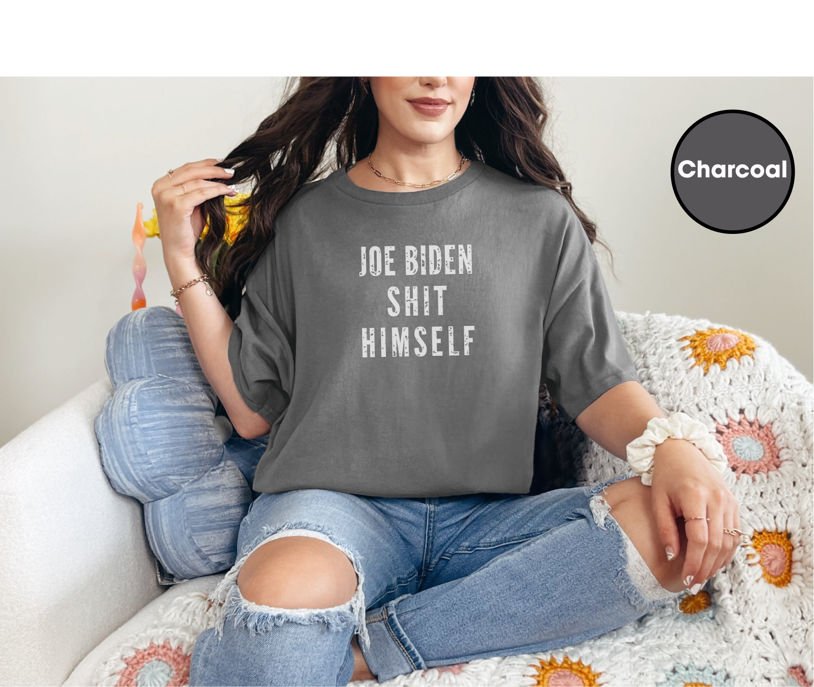 a woman sitting on a couch wearing a t - shirt that says joe biden