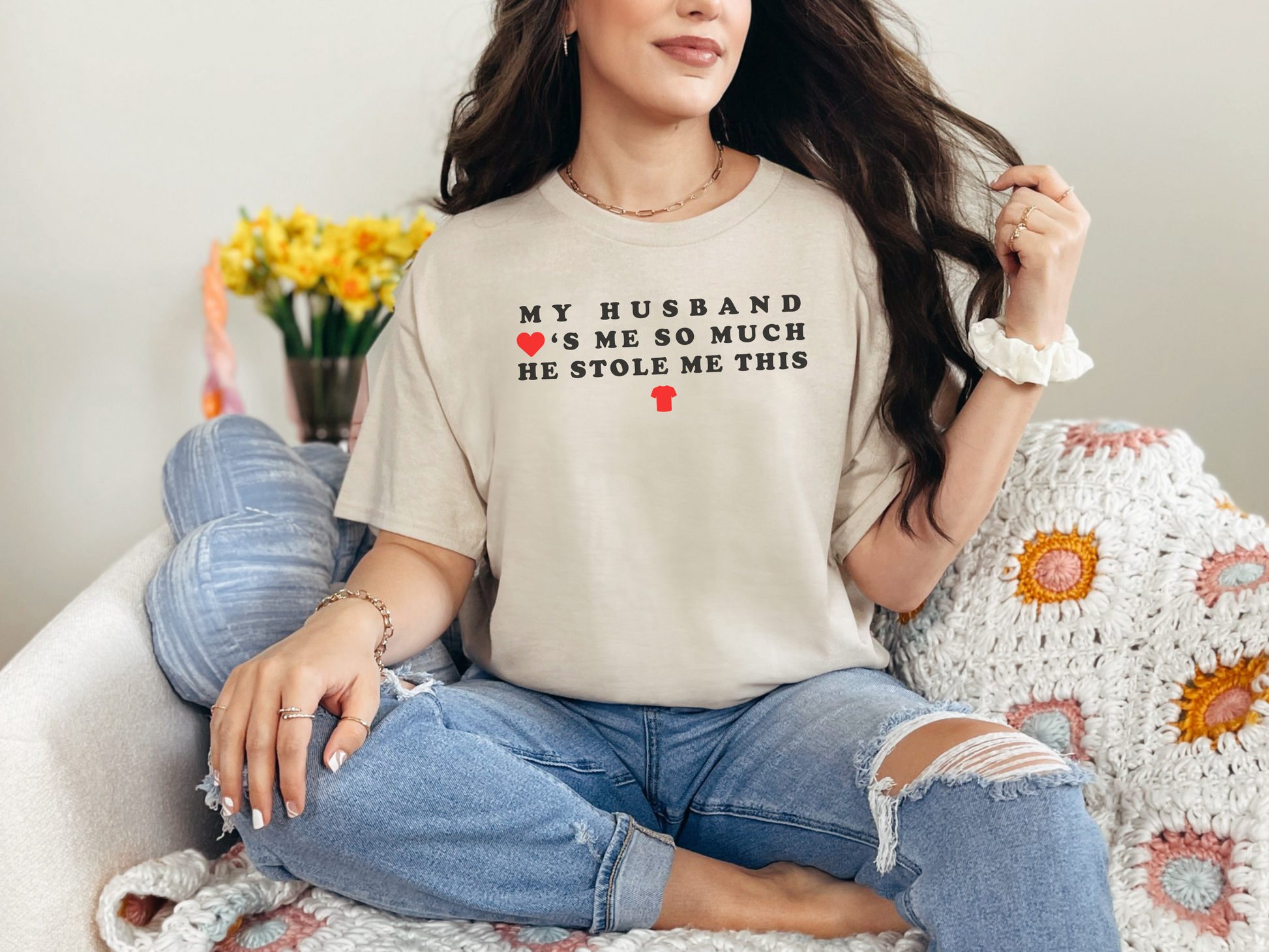 a woman sitting on a couch wearing a t - shirt that says, my husband