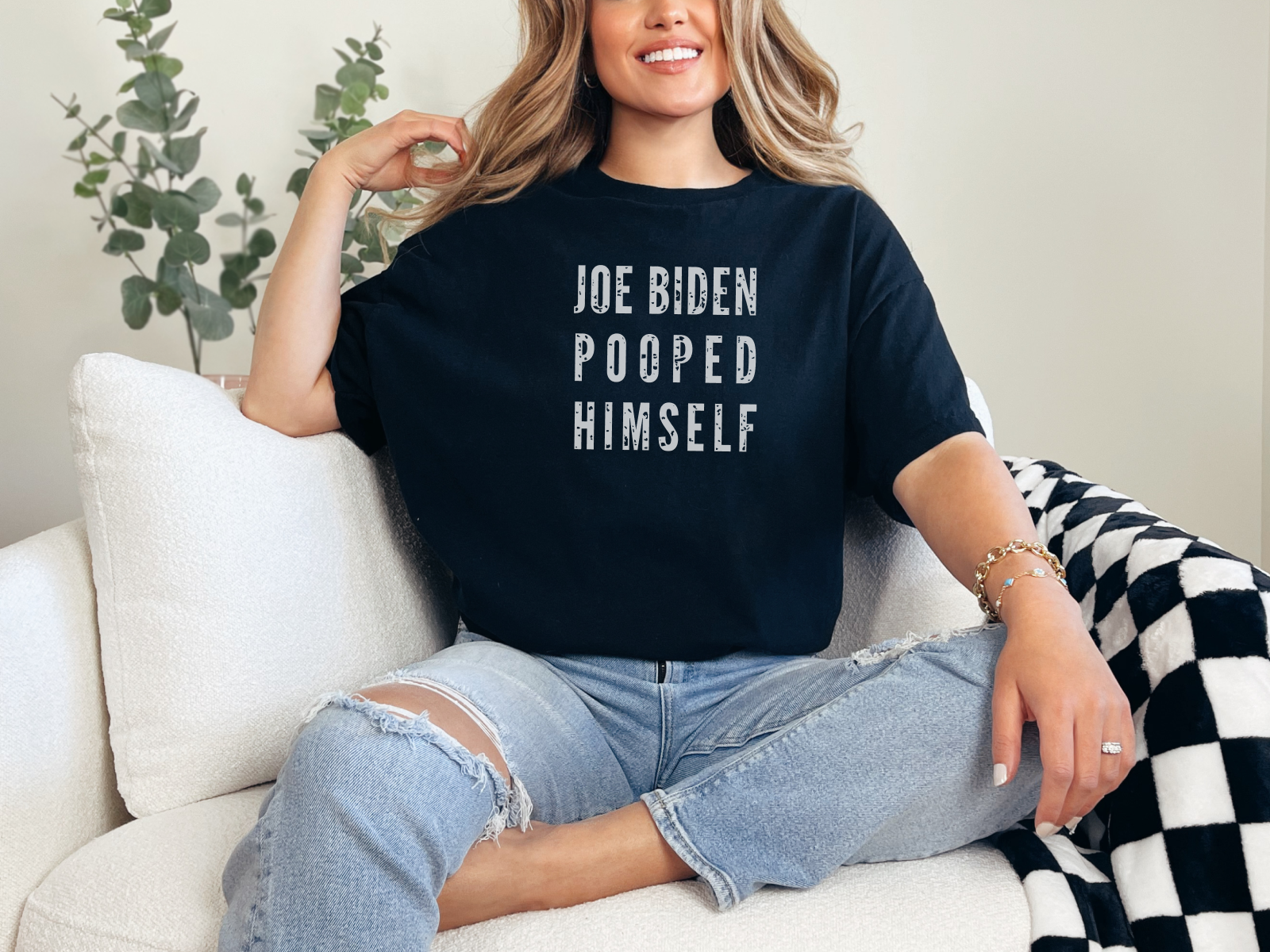 a woman sitting on a couch wearing a t - shirt that says joe boden