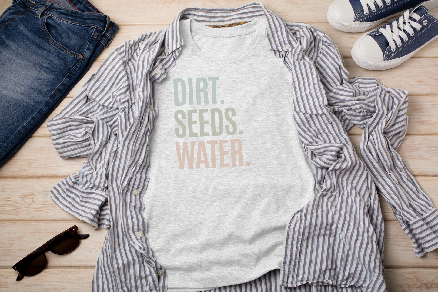 a shirt that says dirt seeds water next to a pair of jeans