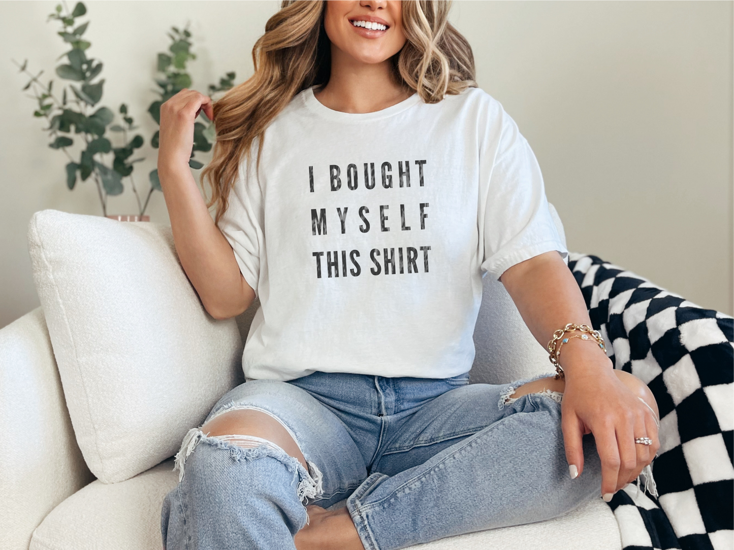 a woman sitting on a couch wearing a t - shirt that says i bought my