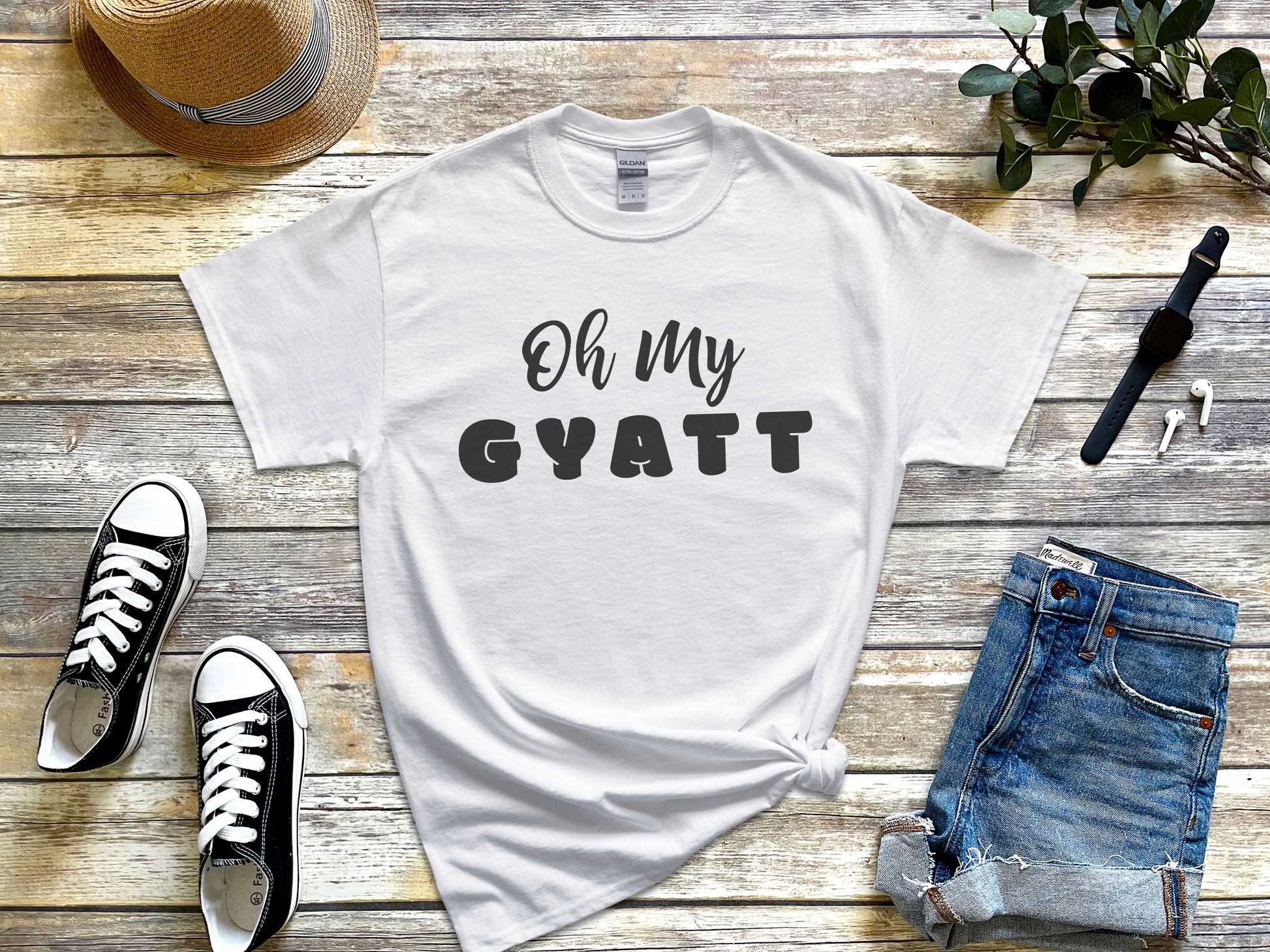 a t - shirt that says oh my gyatt next to a pair of