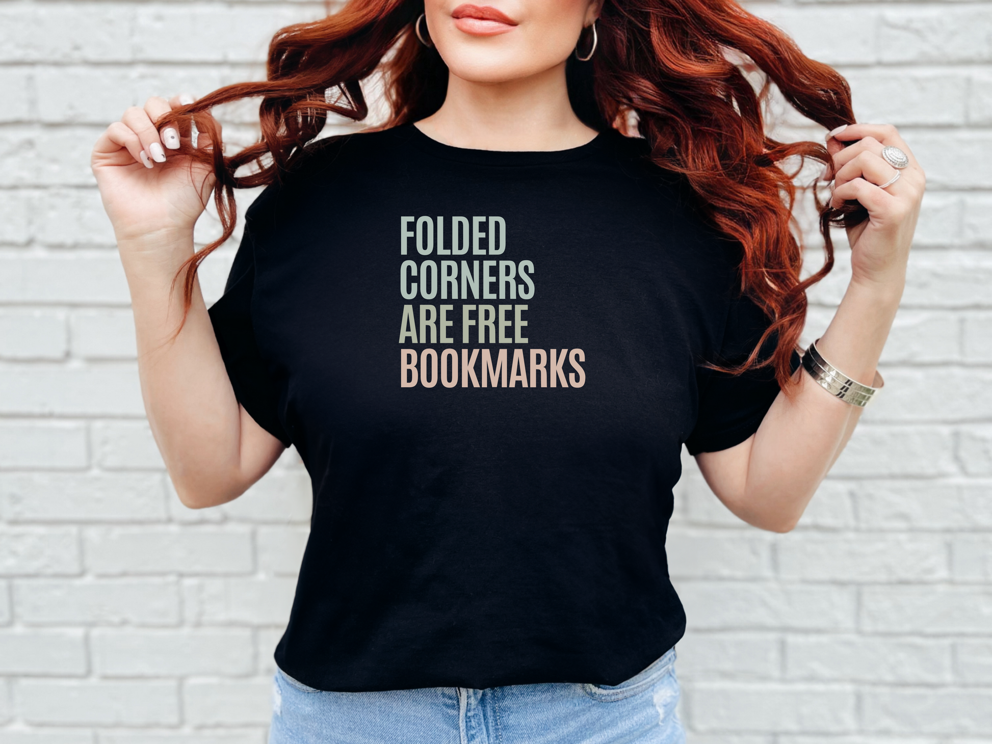 a woman wearing a black t - shirt that says folded corners are free bookmarks