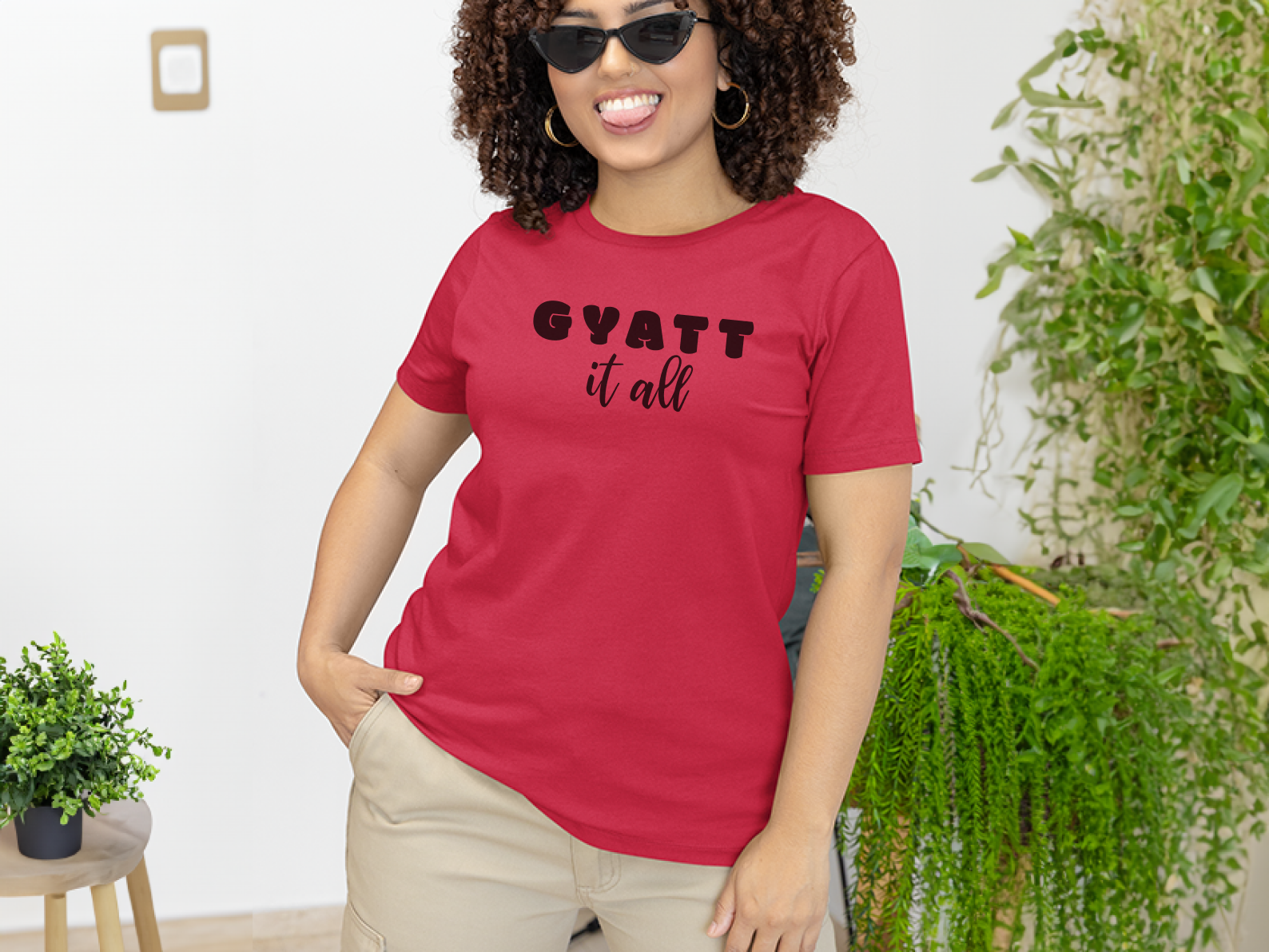 a woman wearing a red shirt that says gyatt it all