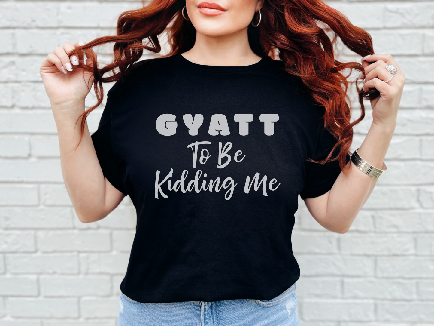 a woman with red hair wearing a black shirt that says gyatt to be